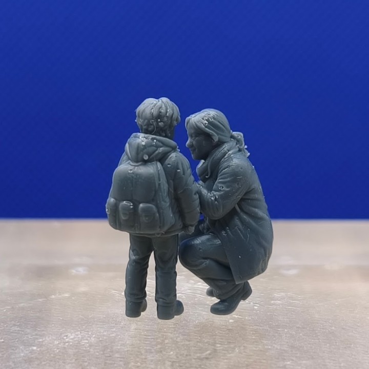 Maman agenouillée face à son garçon portant un sac à dos, diorama 1:43
