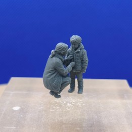 Maman agenouillée fermant la veste de son garçon dans un diorama 1:43