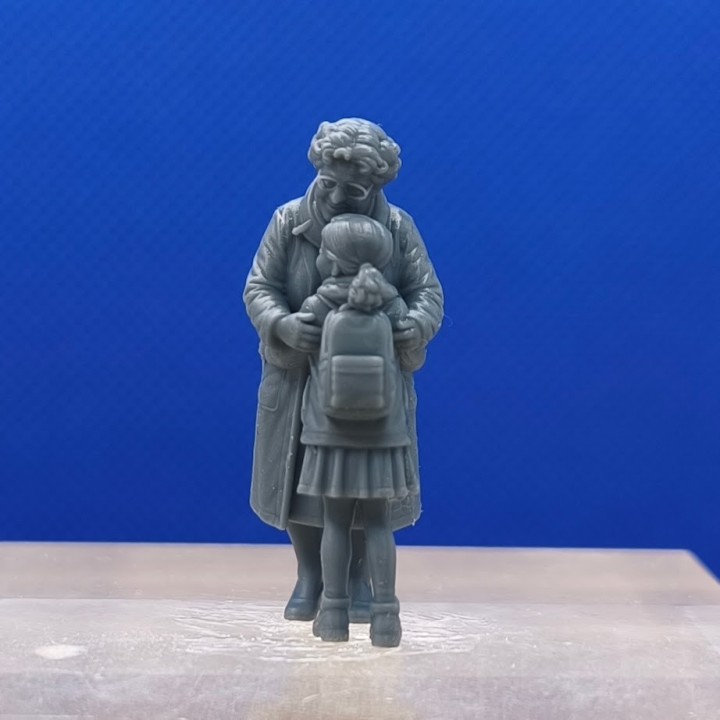 Mamie enlacée avec sa petite-fille vue de dos, avec le sac à dos de l’enfant visible