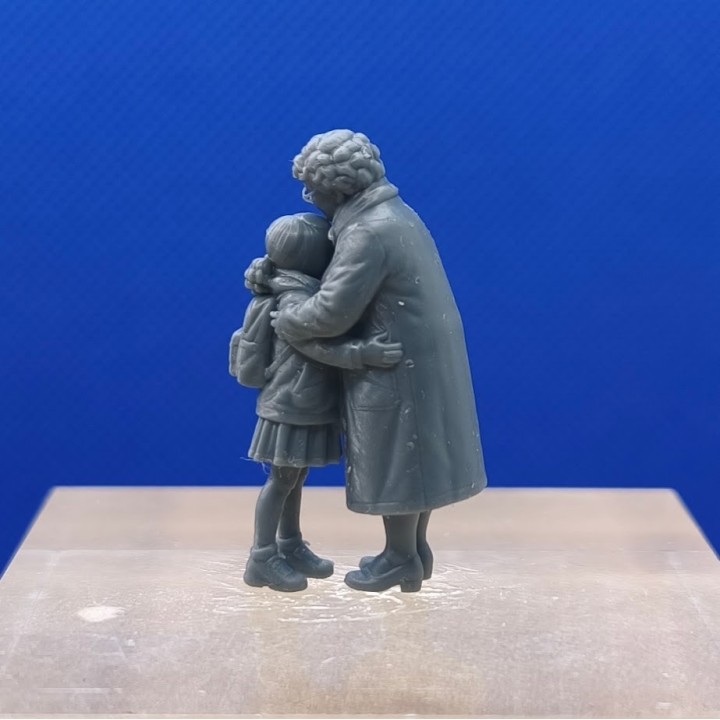 Mamie et sa petite-fille enlacées vues de côté, avec le sac à dos de l’enfant