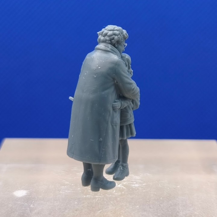 Mamie serrant sa petite-fille, scène observée depuis l’arrière de la grand-mère