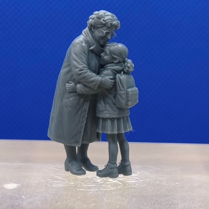 Mamie et sa petite-fille enlacées, avec le sac à dos de l’enfant visible de trois quarts