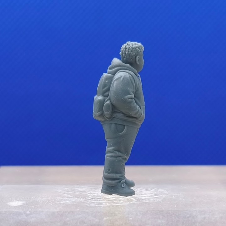 Garçon en sweat à capuche 1:43 avec sac à dos visible, vu de profil