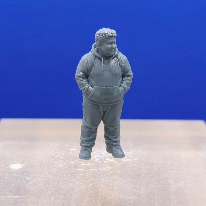 Garçon en sweat à capuche 1:43 avec sac à dos et mains dans les poches, vu de face