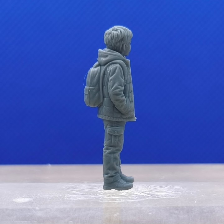 Garçon avec veste à capuche et sac à dos 1:43 vu de profil