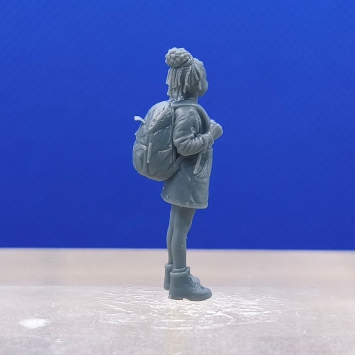 Fillette 1:43 vue de profil avec son cartable visible dans le dos