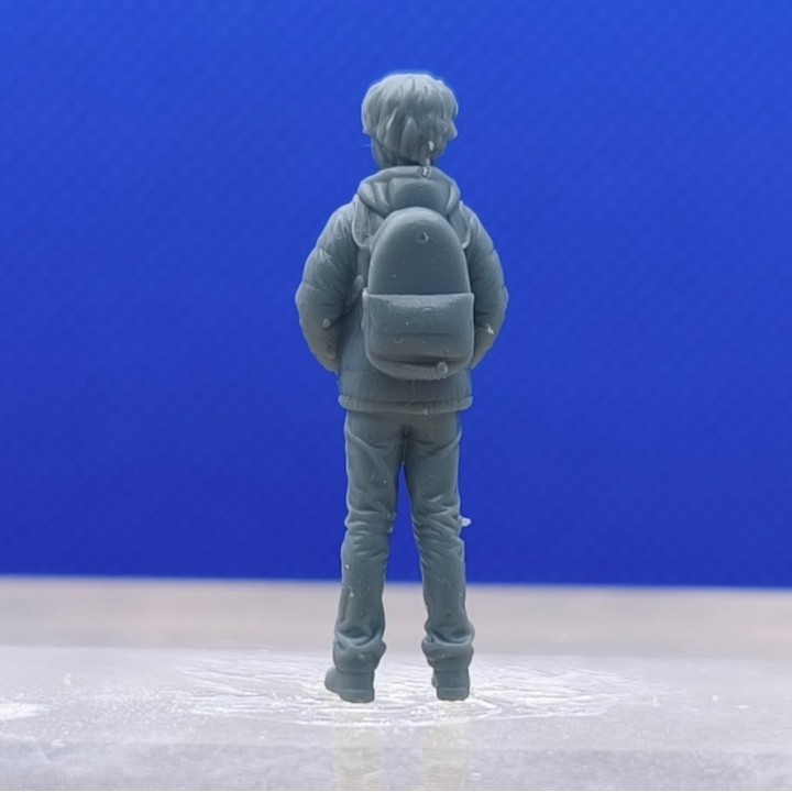 Figurine de garçon 1:43 vue de dos avec son sac à dos
