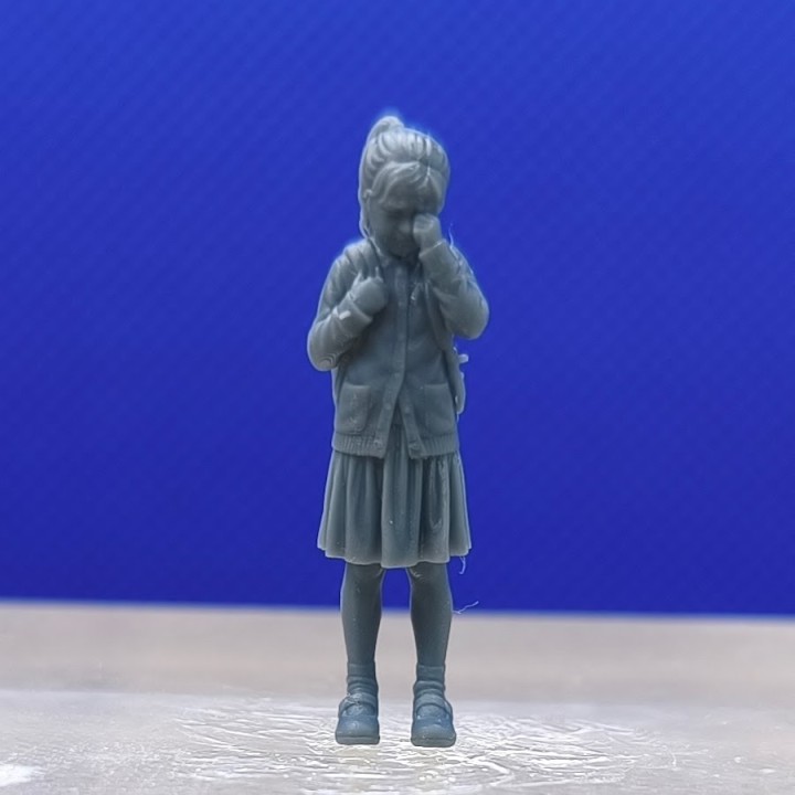 Fillette qui pleure à l’échelle 1:43 avec une main portée au visage, vue de face