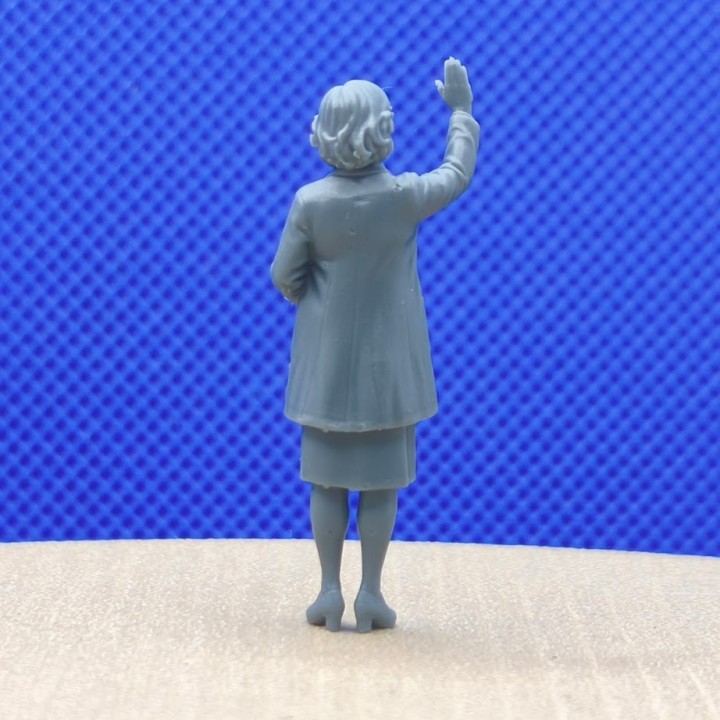 Femme à l’échelle 1:43 levant la main pour saluer, vue de dos