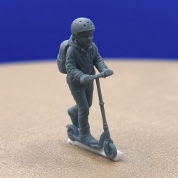 Enfant en trottinette avec casque et sac à dos à l’échelle 1:43, vue de trois quarts avant
