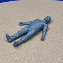 Figurine d’homme allongé au sol à l’échelle 1:43, vue rapprochée depuis les pieds