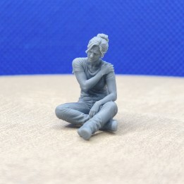 Femme assise se tenant l’épaule, personnage 3D Creative à l’échelle 1:43 vu de face