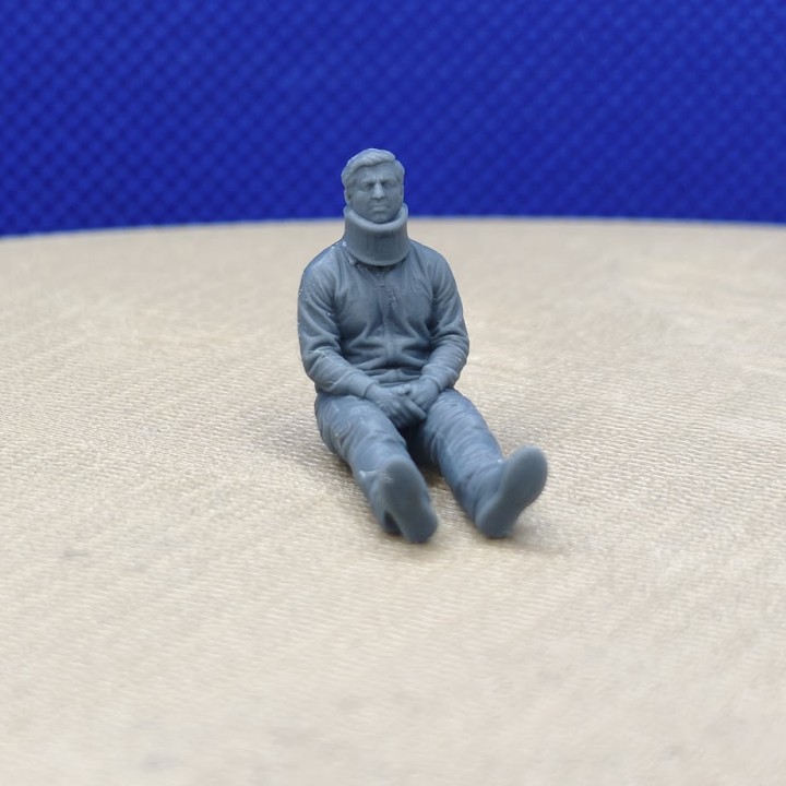 Homme assis avec une minerve à l’échelle 1:43 présenté de face