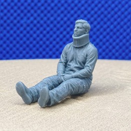 Homme assis avec une minerve à l’échelle 1:43 présenté de trois quarts