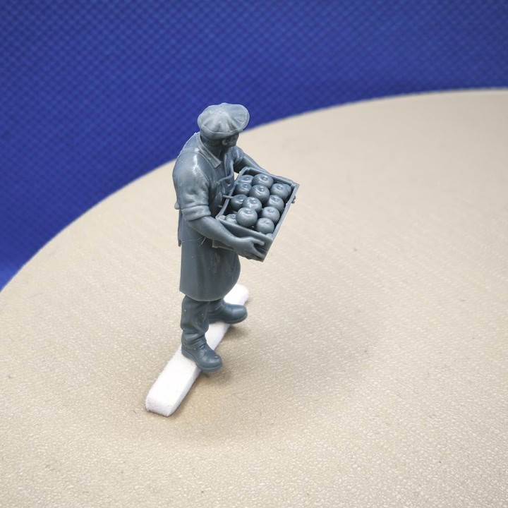 Scène miniature de marché avec un maraîcher et sa cagette de pommes à l’échelle 1:43