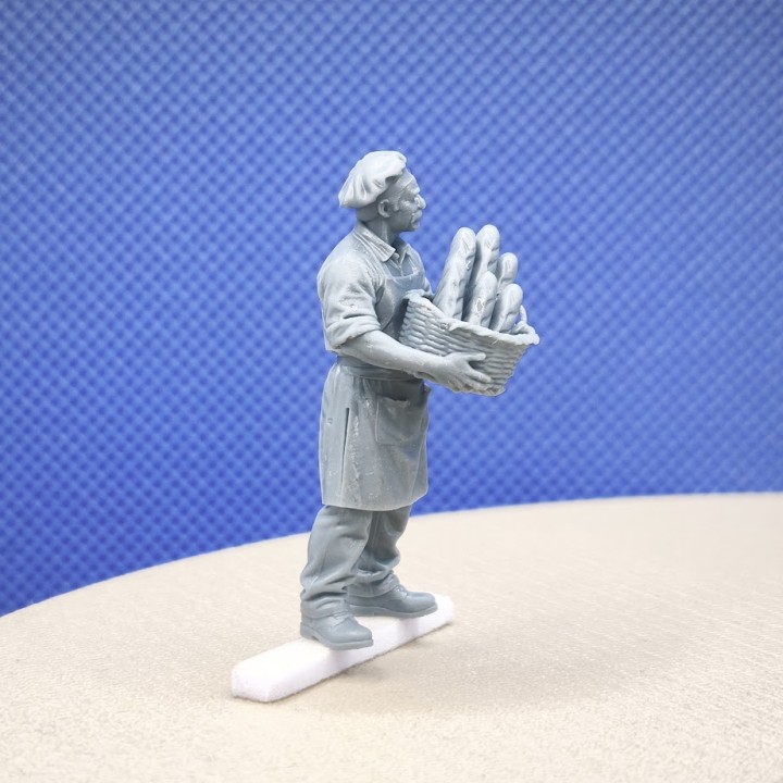 Boulanger miniature 1:43 portant un panier de pains pour scène de marché