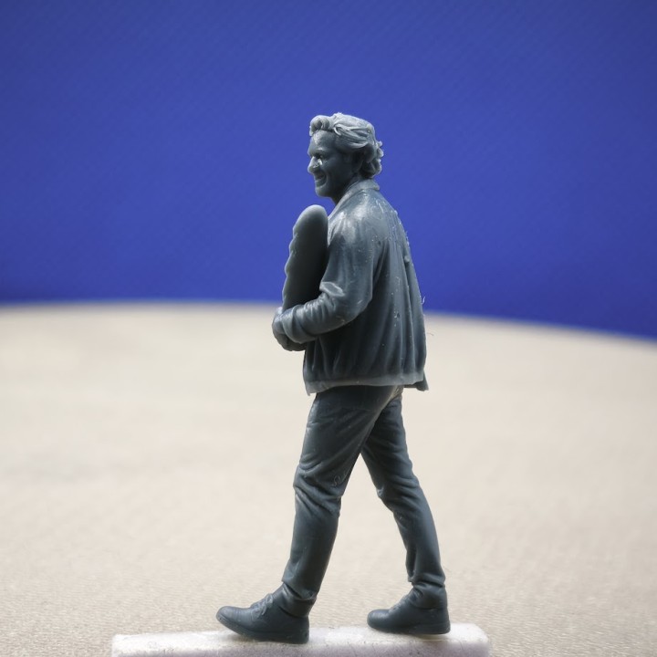 Vue de profil d’une figurine d’homme marchant avec une baguette à l’échelle 1:43