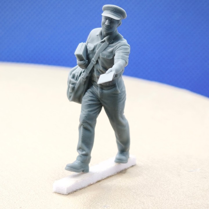 Figurine de facteur au 1:43 tenant une lettre, vue de trois quarts